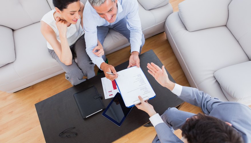 Salesman showing contract to couple who are about to sign