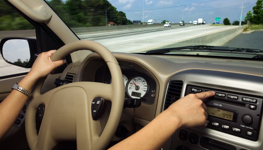 Hands of woman driving and using radio