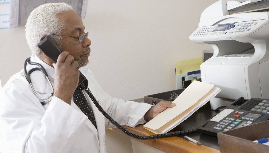 African American senior male doctor holding document while using phone