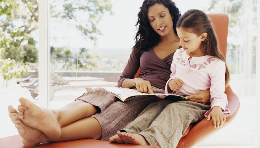 Young girl reading a book with her mother. Young girl reading a book with her mother.