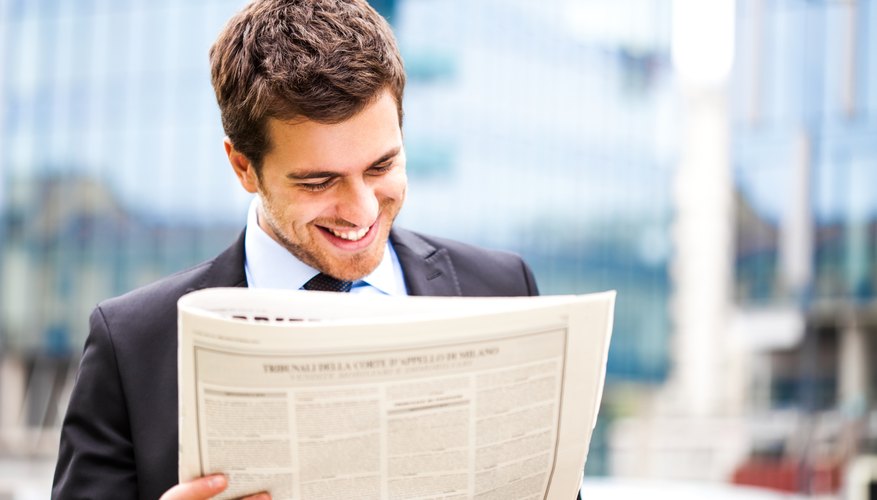 Young man reads morning newspaper