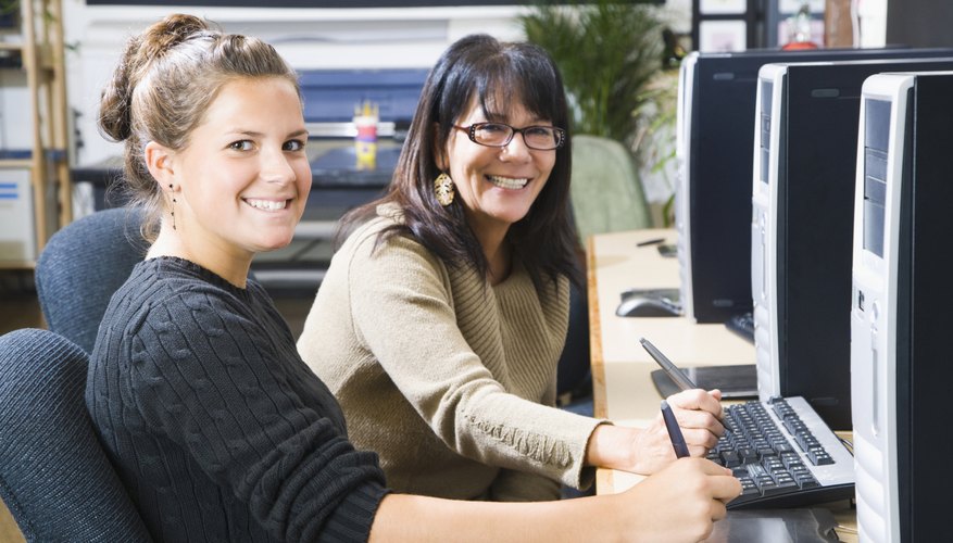 Student with her professor in a computer class