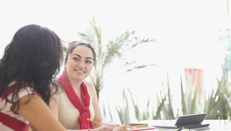 Side profile of two young women working together