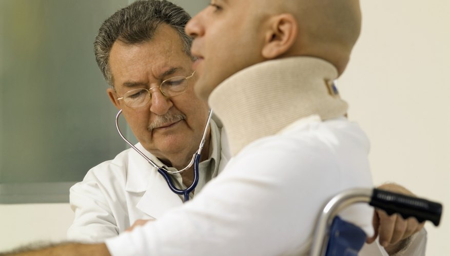 Male doctor examining a male patient in a wheel chair