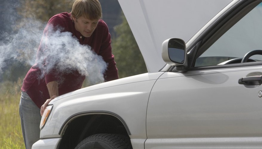 Man leaning on car with bonnet open at roadside