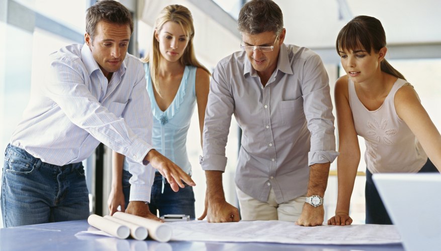 Photo Credit: George Doyle/Stockbyte/Getty Images Designers with blueprints in office.