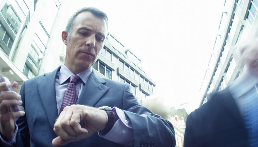 Businessman Looking at his Watch with Blurred People in the Background