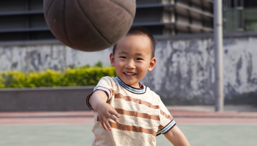 A young boy throws a basketball. A young boy throws a basketball.