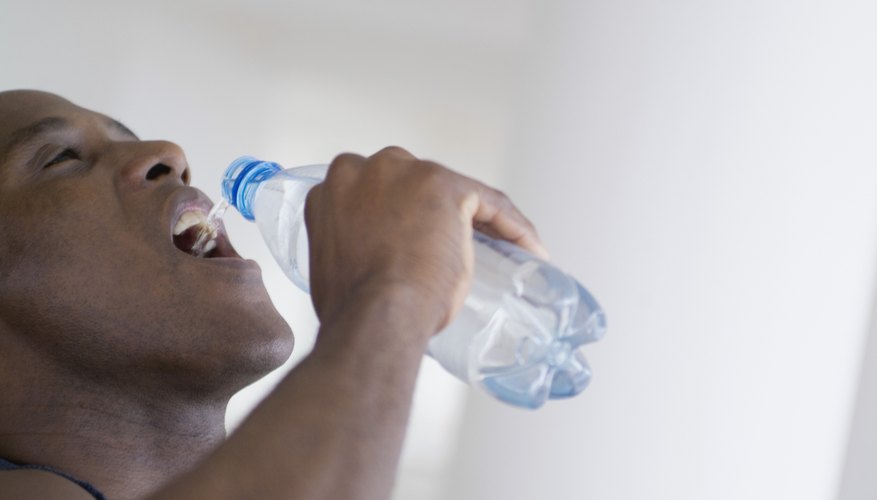 Man chugging a bottle of water. Man chugging a bottle of water.