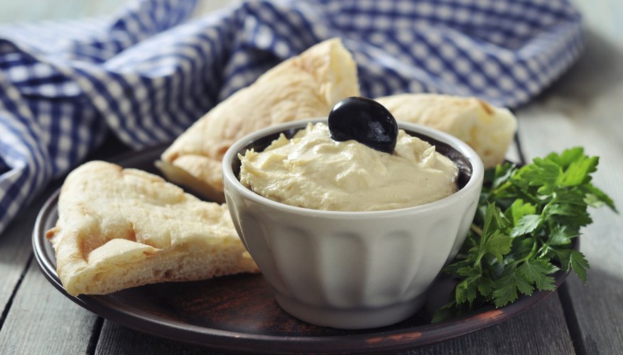 A bowl of fresh humus with slices of pita. A bowl of fresh humus with slices of pita.