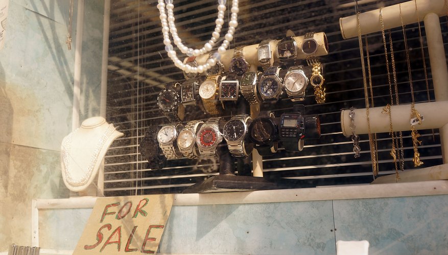 A close-up of items for sale in a pawn shop window.