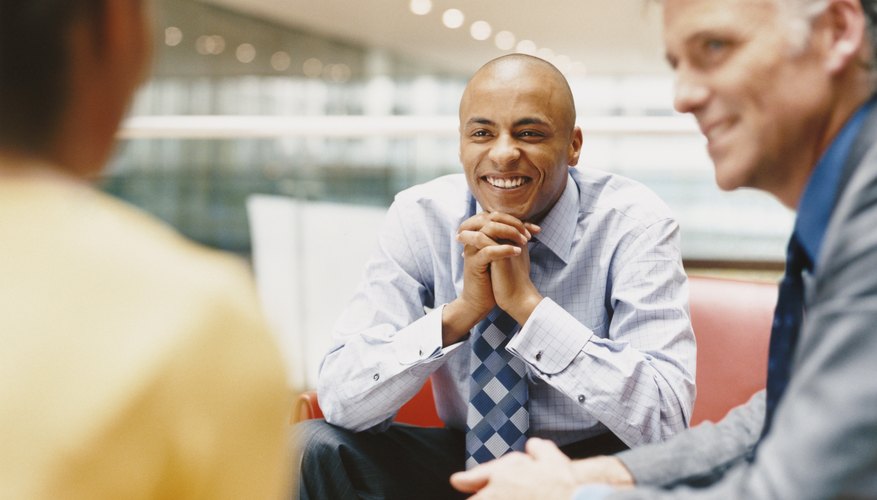 Business People Sitting on Chairs Chatting in an Office Building