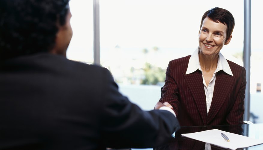 businesswoman and a businessman shaking hands in a conference room