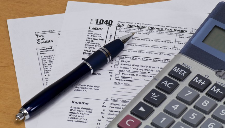 Income tax form with calculator and pen.