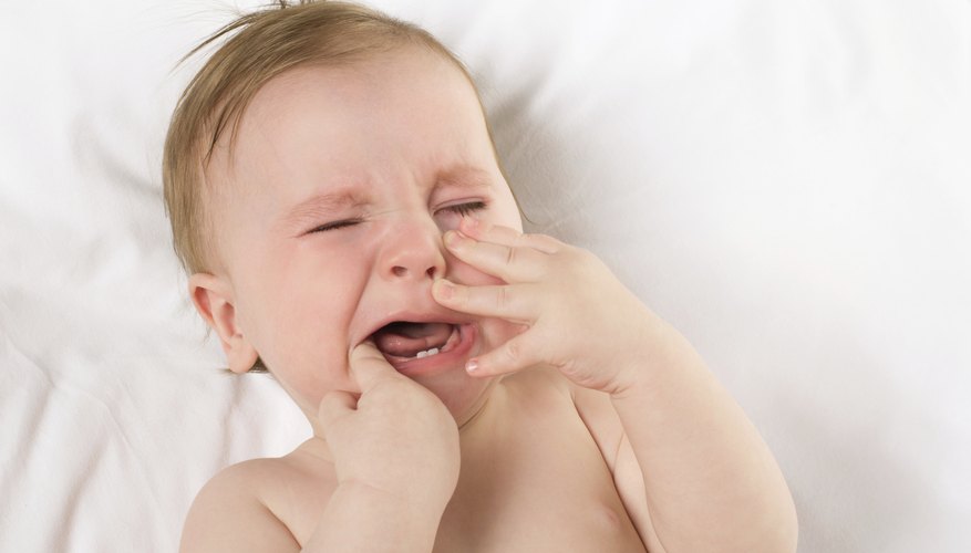 A baby may cry and chew on fingers while teething. A baby may cry and chew on fingers while teething.