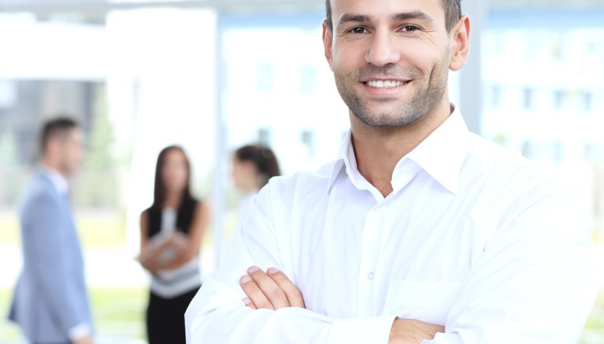 Cross-armed leader looking at camera in working environment