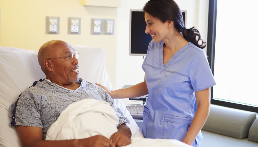 Nurse Talking To Senior Male Patient In Hospital Room