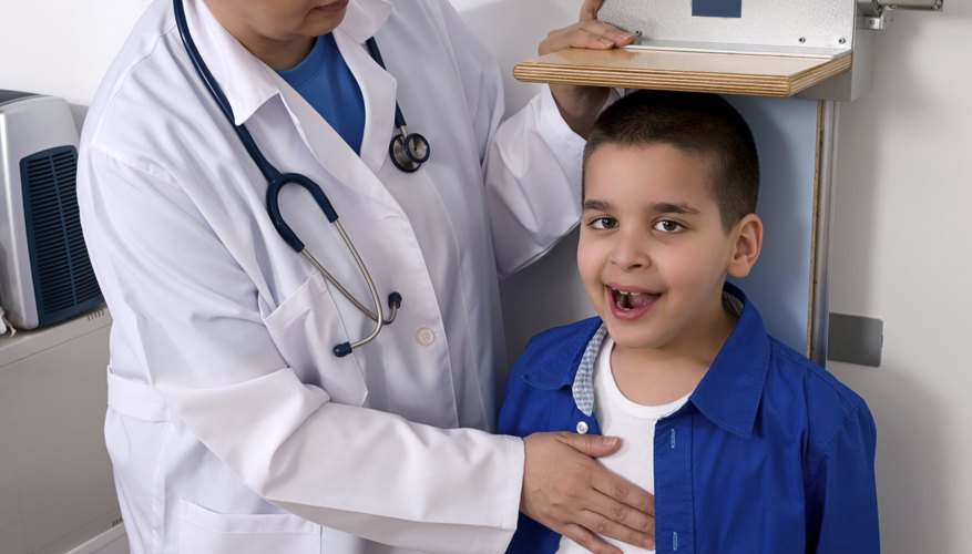 A doctor measuring a young boy's height. A doctor measuring a young boy's height.