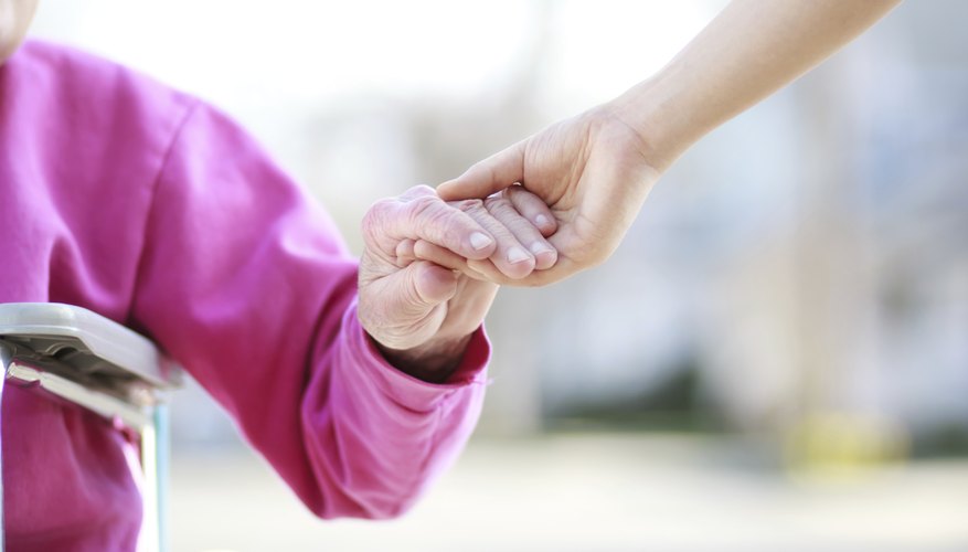 Photo Credit: Melpomenem/iStock/Getty Images Woman holding elderly woman's hand