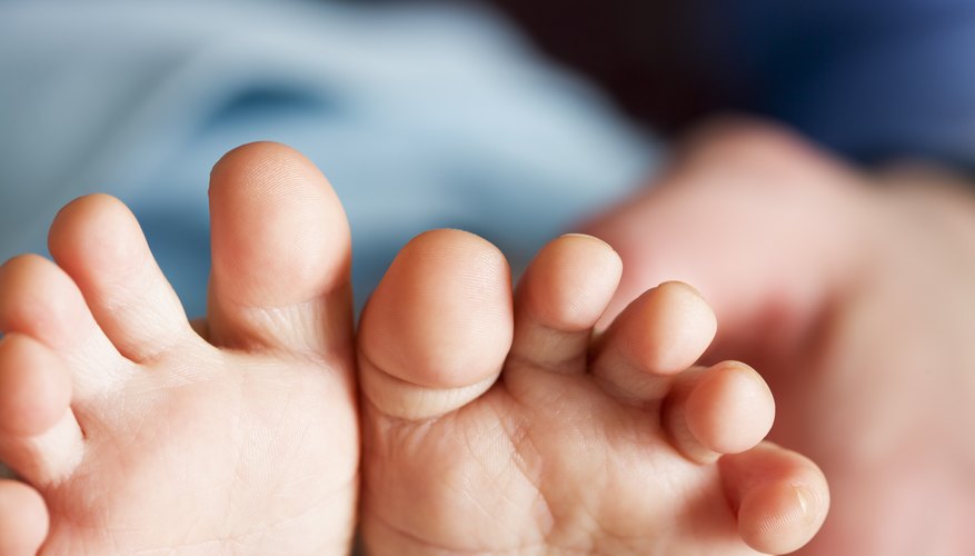 A close-up of a dad counting his child's toes. A close-up of a dad counting his child's toes.
