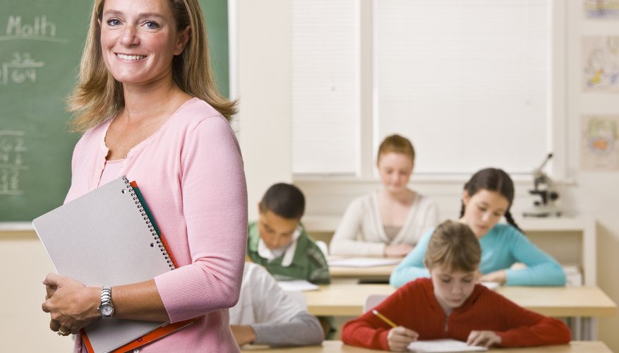Photo Credit: AVAVA/iStock/Getty Images A smiling math teacher in class.