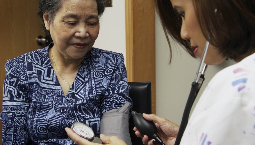 Photo Credit: Vstock LLC/VStock/Getty Images Nurse checking mature woman's blood pressure.