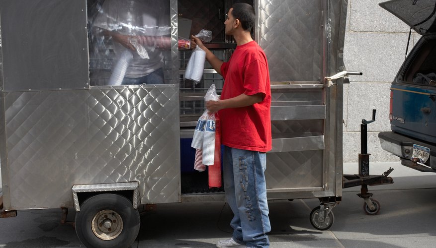 Photo Credit: Andrew Hetherington/Stockbyte/Getty Images Men stock a food cart in Brooklyn, NY