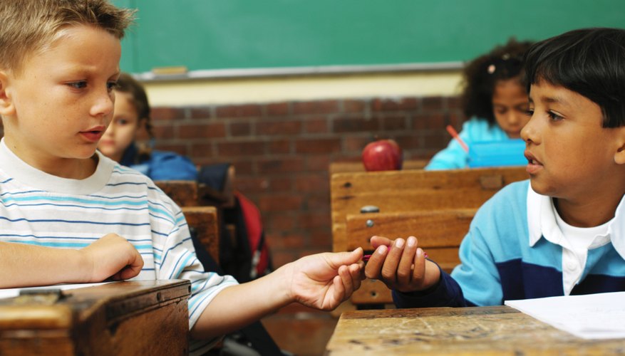 Two kids are passing notes in school. Two kids are passing notes in school.