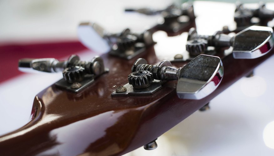 Afinar una guitarra con un afinador.
