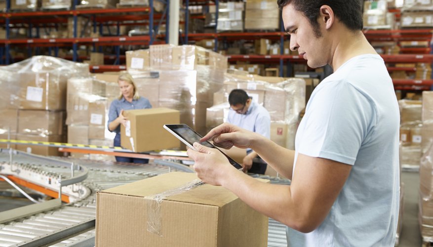 Worker Using Tablet Computer In Distribution Warehouse