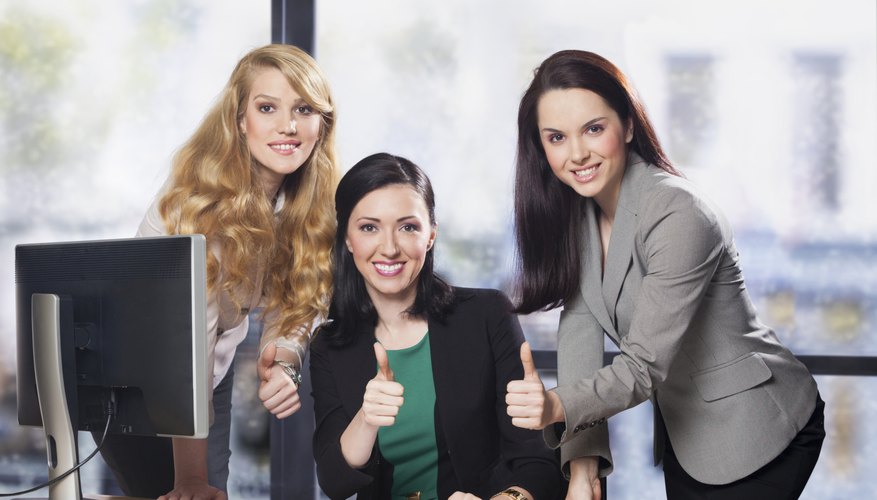 Three businesswomen showing thumbs up
