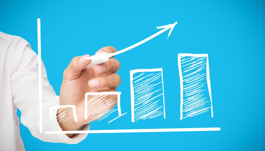 Businessman drawing white arrow above graph