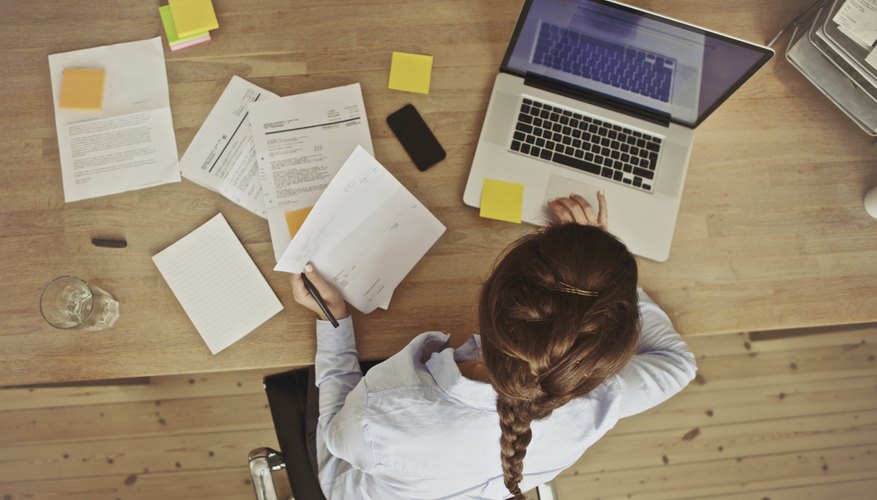 Businesswoman working at her office desk with documents and laptop