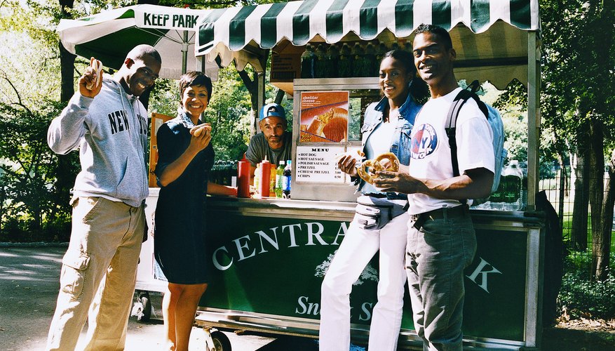 Portrait of Tourists in Central Park in New York City Holding Food in Front of a Hot Dog Stand