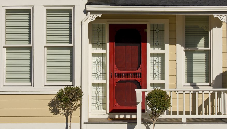 A red wooden door on a sunny porch. A red wooden door on a sunny porch.
