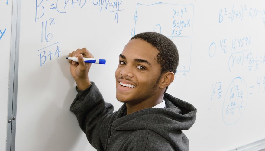 Student working on Algebra problems on whiteboard. Student working on Algebra problems on whiteboard.