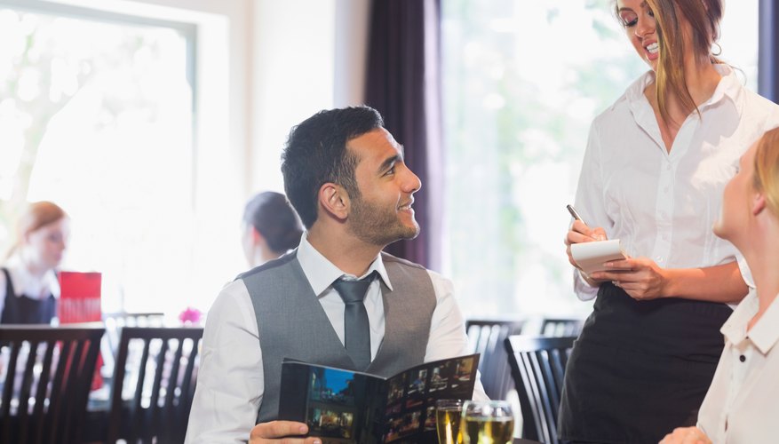 Photo Credit: Wavebreakmedia Ltd/Wavebreak Media/Getty Images A restaurant patron ordering from a waitress.