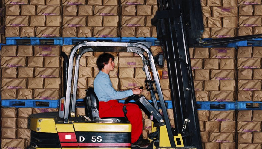 side profile of a young man driving a forklift in a warehouse