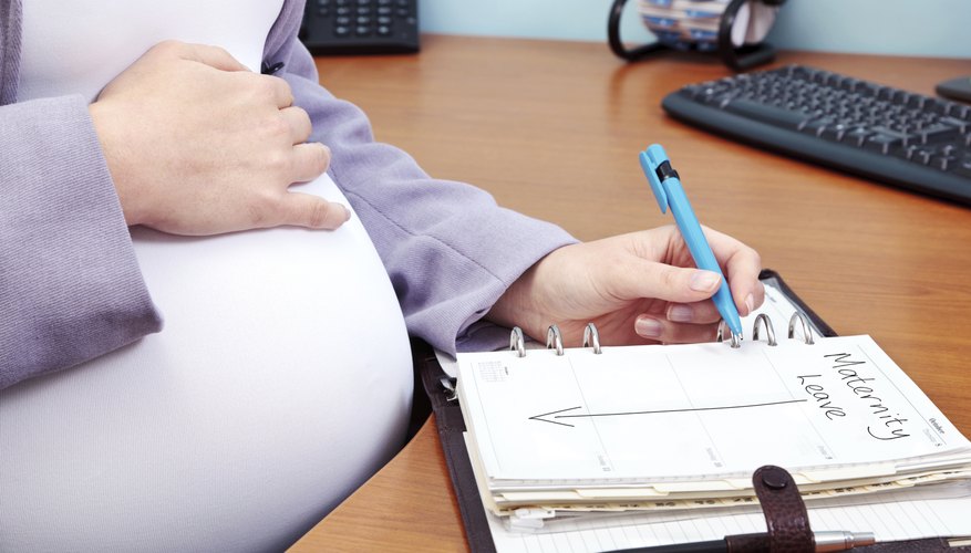 A pregnant woman at work filling out her calendar for maternity leave. A pregnant woman at work filling out her calendar for maternity leave.