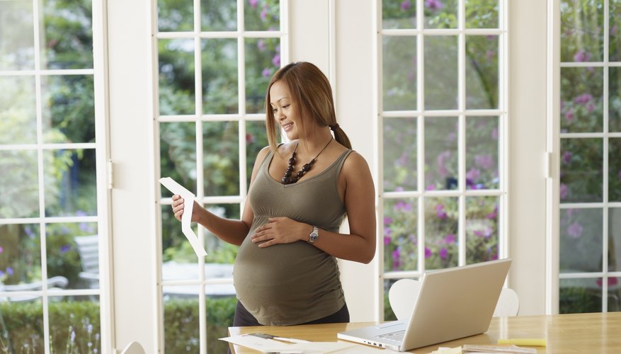Pregnant woman reading a piece of paper. Pregnant woman reading a piece of paper.