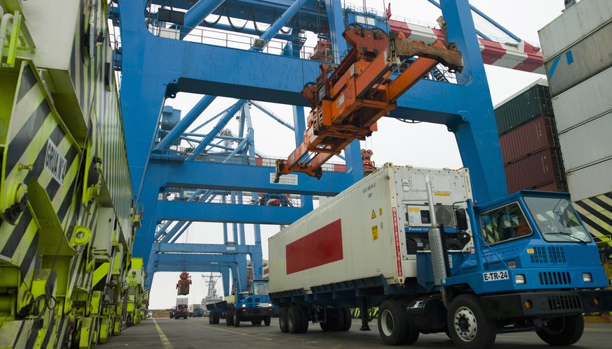 Container being loaded onto truck in shipping yard