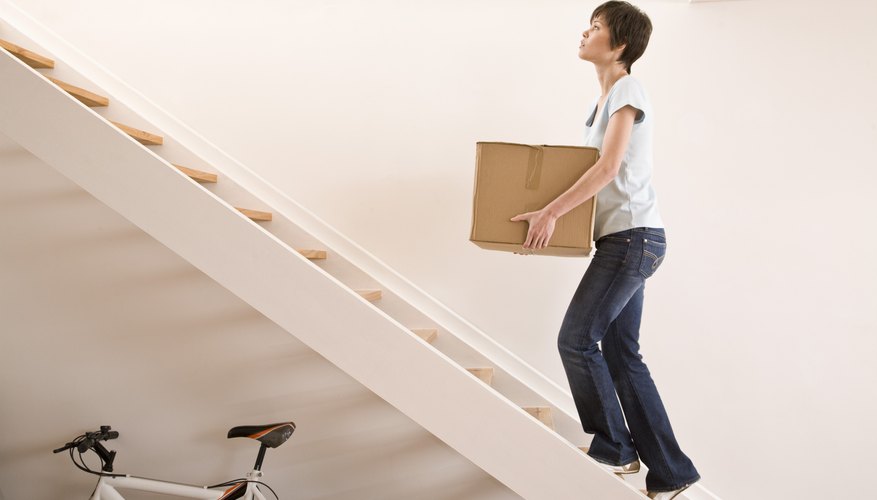 Woman carrying box up stairs Woman carrying box up stairs