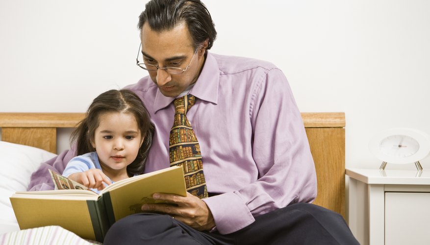 Father reading to his daughter in bed. Father reading to his daughter in bed.