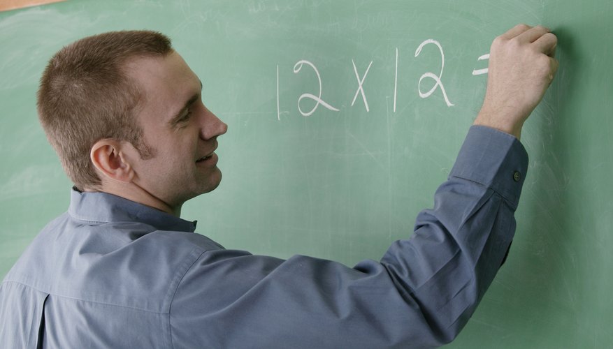 Teacher writing multiplication on board. Teacher writing multiplication on board.