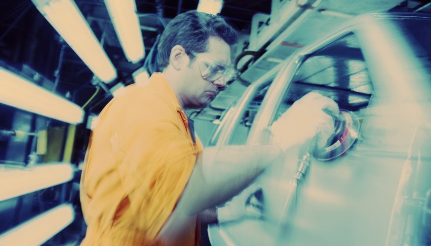 Male worker on assembly line in car manufacturing plant