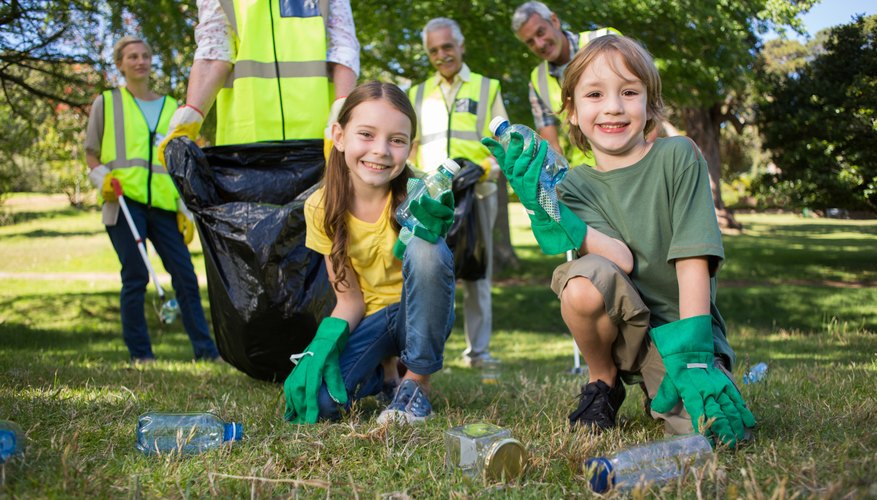 A family cleaning up litter in a park. A family cleaning up litter in a park.