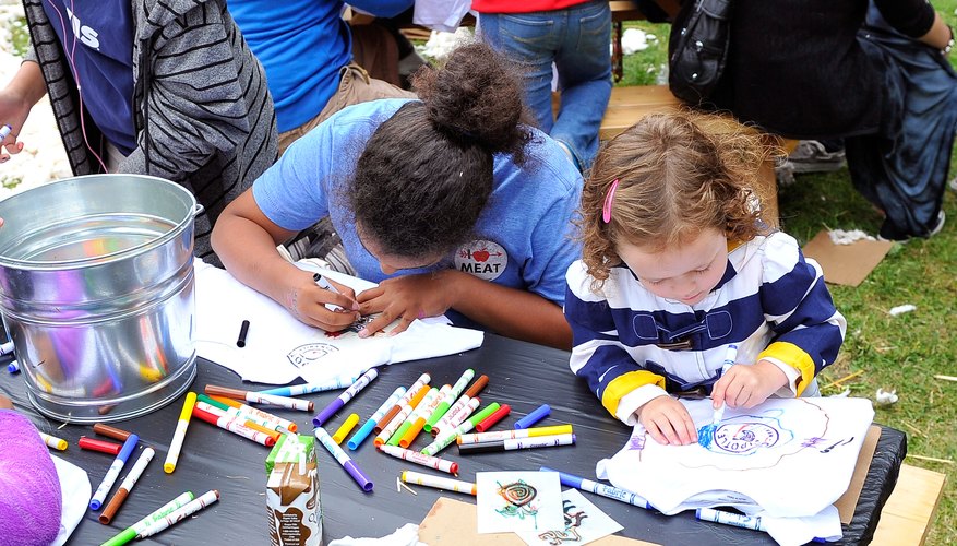 Kids making art at a table during a festival. Kids making art at a table during a festival.