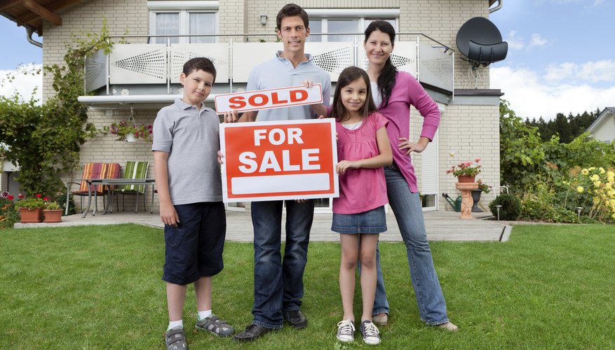 Family standing in front of a newly sold house.