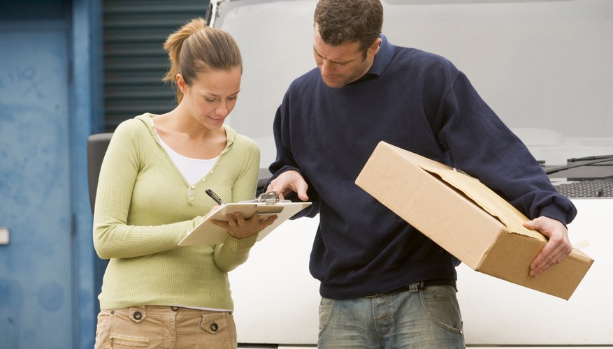 Photo Credit: Catherine Yeulet/iStock/Getty Images Manager going over papework with delivery driver