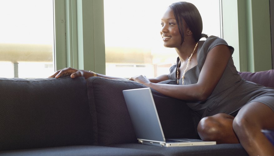 Photo Credit: Todd Wright/Blend Images/Getty Images A businesswoman sitting on the couch in front of her laptop.
